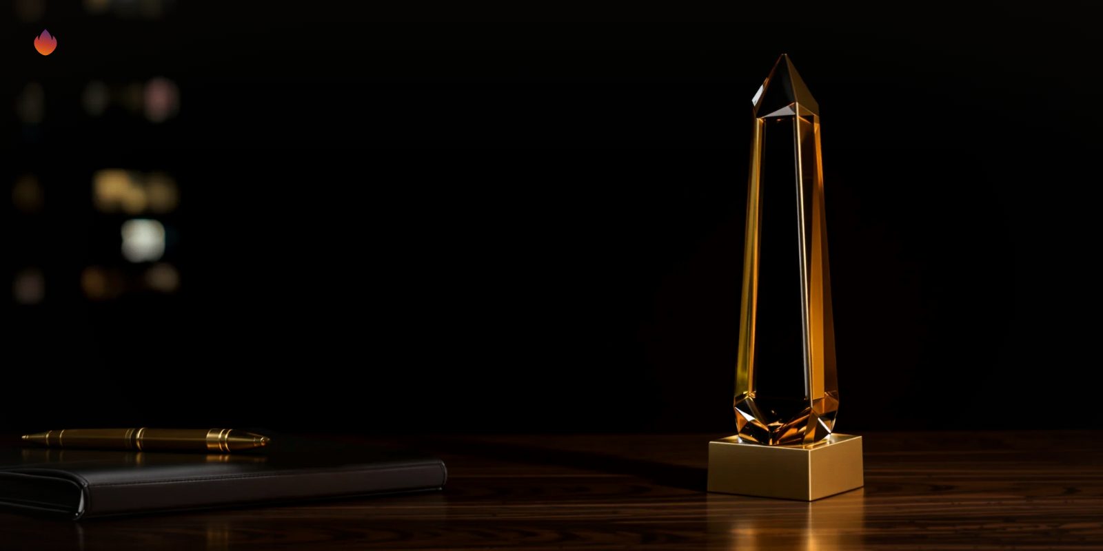 A brass and amber glass award on a walnut desk in a dark office at night