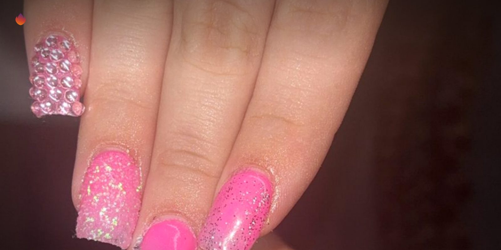 A set of hot pink nails with rhinestones