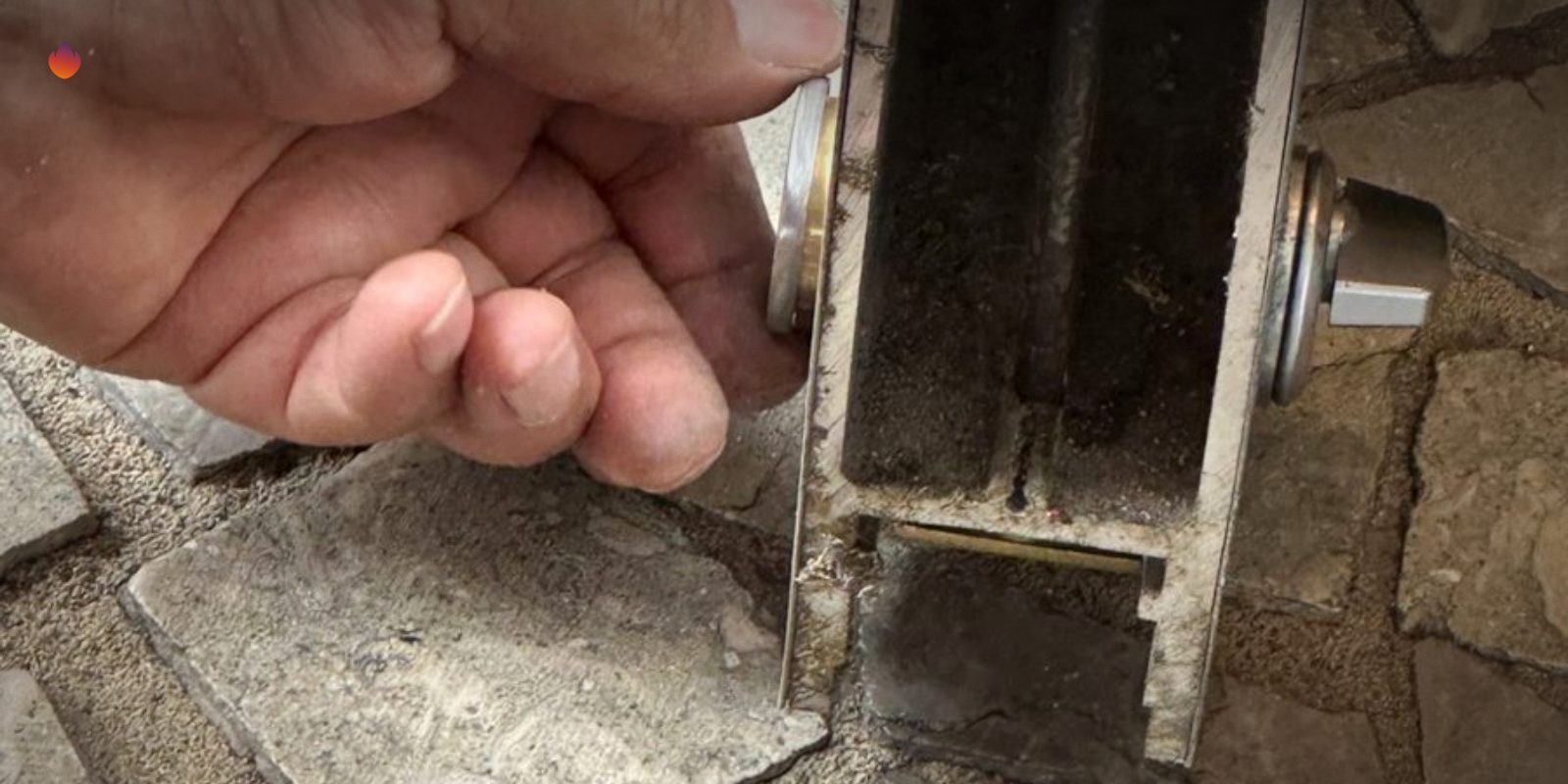 A locksmith's hands holding a mortise lock case pulled from a door