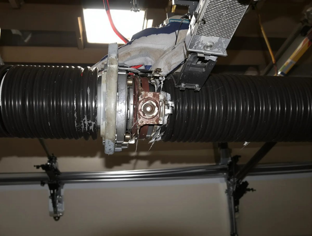 A garage door torsion spring mounted above a closed door, a winding cone at its center