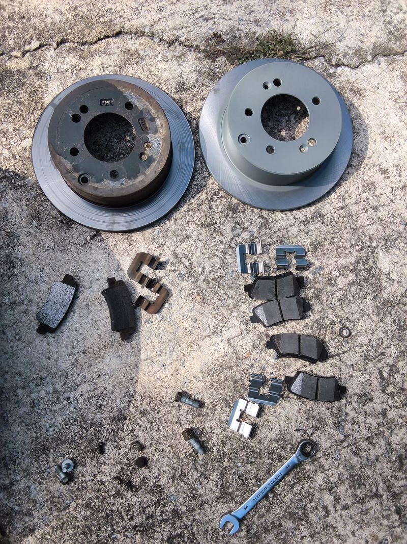 Old and new rotors and pads laid out after a Huey's Mobile brake job in Monroe