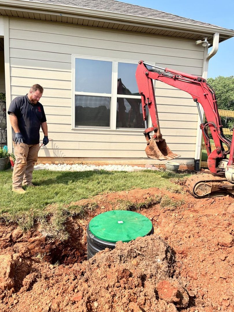 A new septic riser and cleanout beside a customer's house, fresh dirt around them