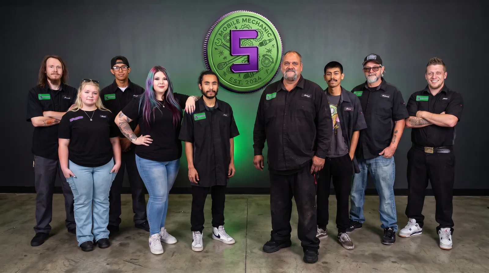 The Supercanic crew lined up under the green Supercanic coin logo