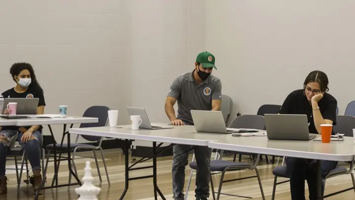 Agents helping people at a fall sign up day in a church hall