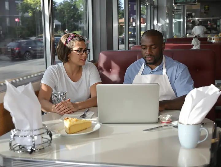 Going over the month with a diner owner in a booth