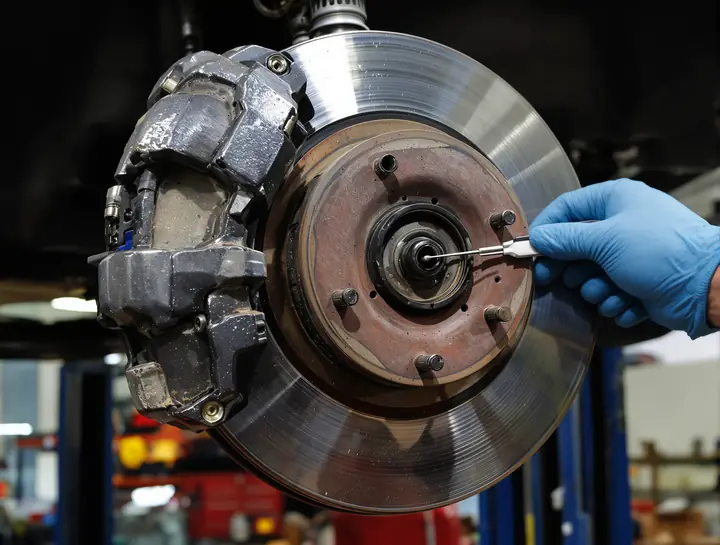Measuring a brake rotor with a micrometer to see if it can be reused