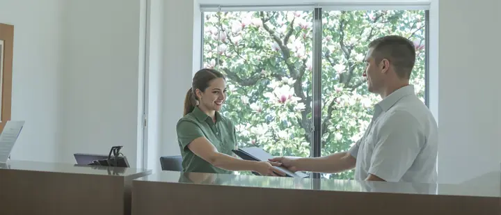 Our paralegal Kayla handing a client his filing packet at the front desk