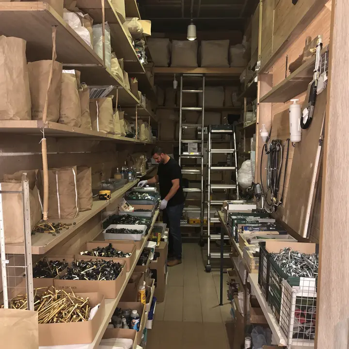 Owner restocking bins in a family hardware store