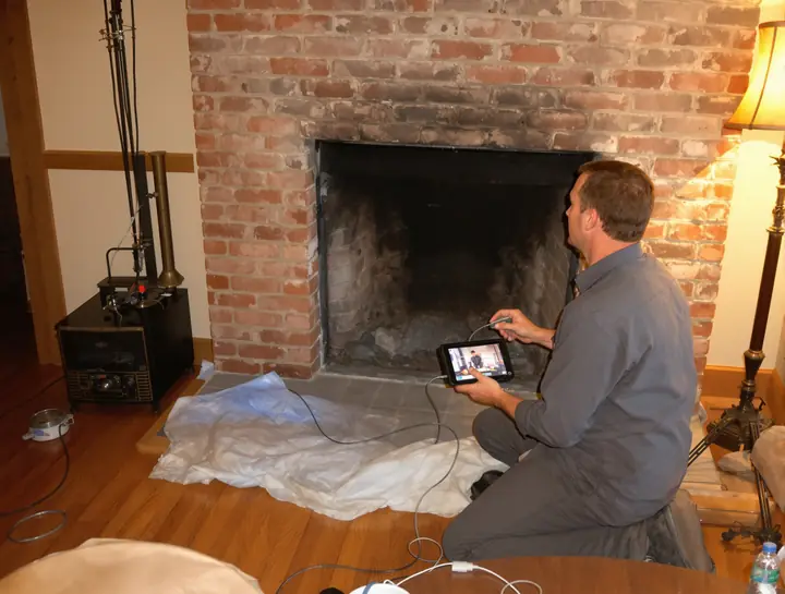 Tech reviewing a chimney camera scan with a homeowner in Newington