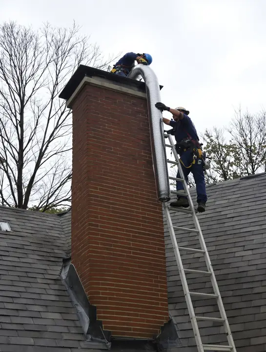 Lowering a stainless liner into a chimney in West Hartford