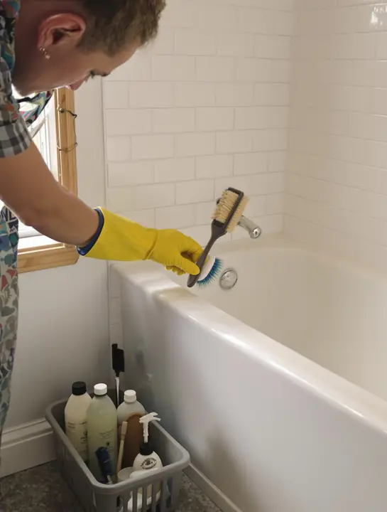 Scrubbing tile grout in a bungalow bathroom