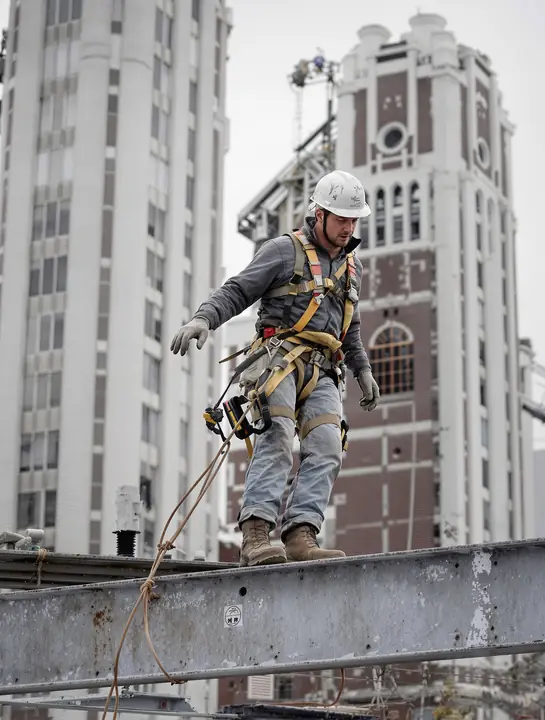 Ironworker walking a steel beam above downtown Detroit