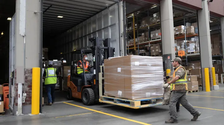 A forklift driver unloading a trailer at an Oakland warehouse dock