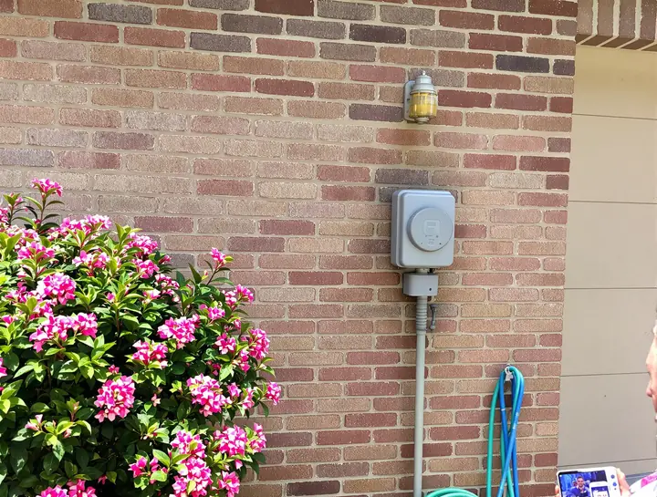 Photographing the meter on a brick house to check the usage history