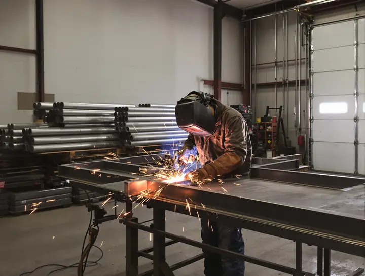 Welder building a gate frame in the shop