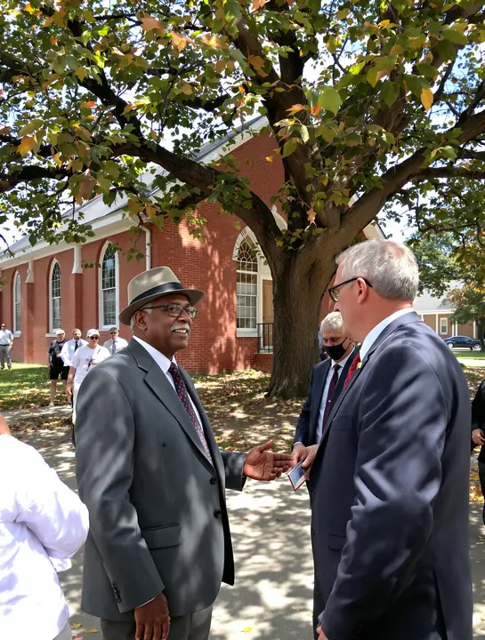 Walter talking with a church member under an oak tree after service