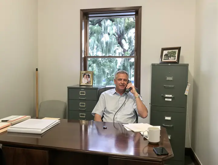 Walter on the phone at his desk in the Pecan Row office