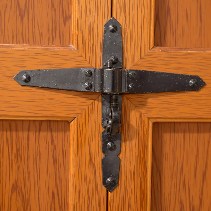 Black strap hinge on a wood grain carriage door