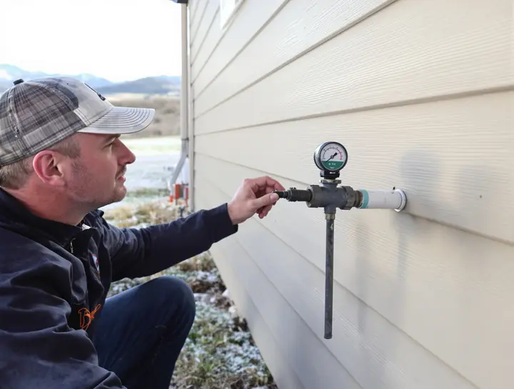 Gas fitter checking pressure at the meter on a frosty morning