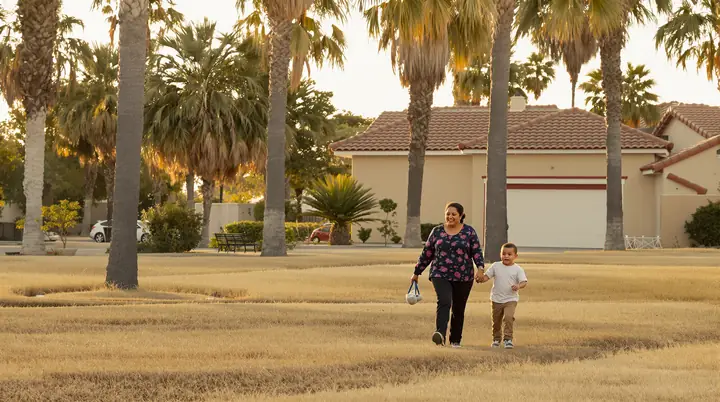 A grandmother and grandson walking in a San Diego park at golden hour