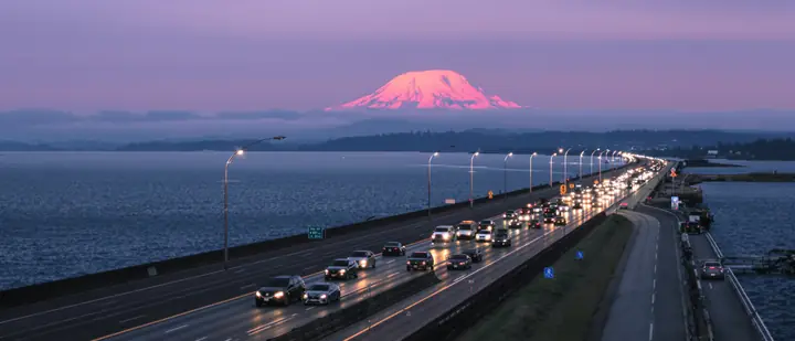 Evening traffic on a bridge near Tacoma with Mount Rainier behind