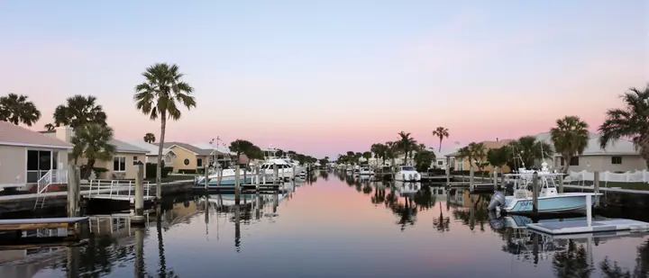 A Cape Coral canal lined with homes and docks at sunrise