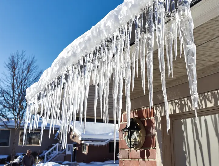 Ice dam and icicles along the eave of a ranch house in Brandon