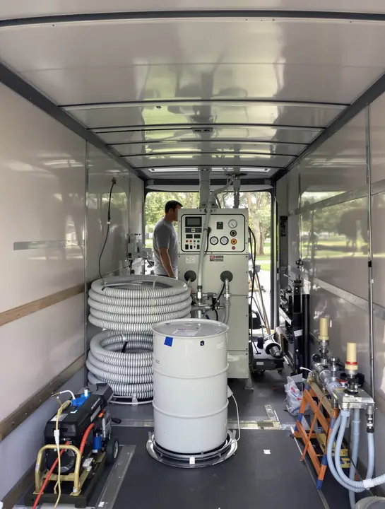 Technician checking the gauges on a spray foam machine inside the rig