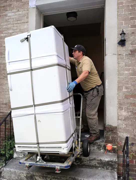 Wheeling an old fridge out of a basement door