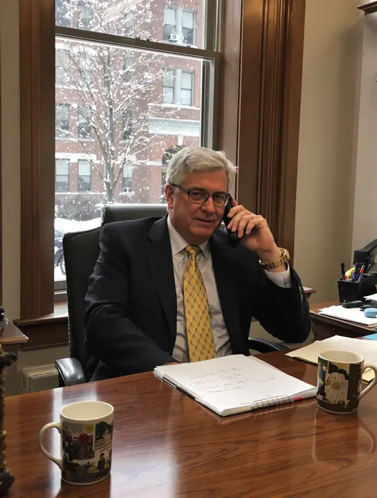 Tom Halloran on a call with a client at his desk on a snowy day