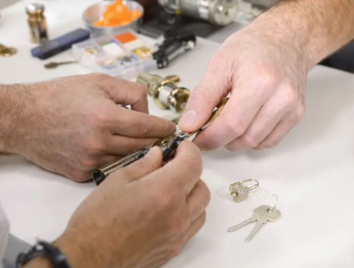 Hands rekeying a knob cylinder with a pin kit