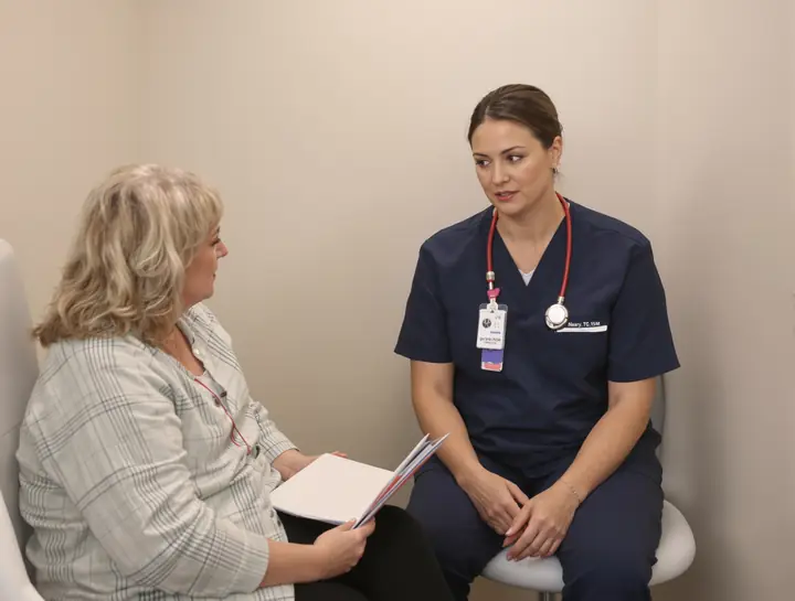 A patient talking with a nurse practitioner in an exam room