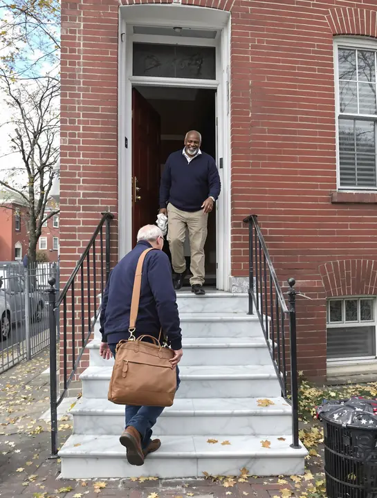 Glenn arriving at a brick rowhouse in the city of Lancaster