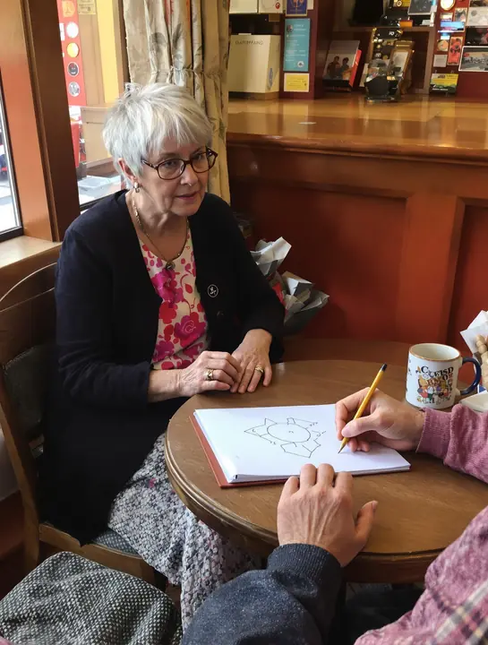 Sketching out IRA fees on a notepad with a customer