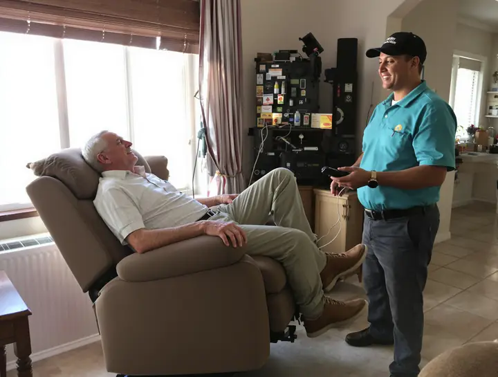 A man using the remote on a power lift recliner