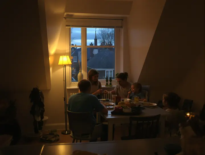 A young family at dinner in a third floor kitchen with a sloped ceiling