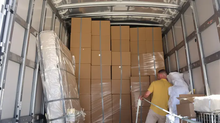 Boxes and wrapped furniture strapped tight inside the truck