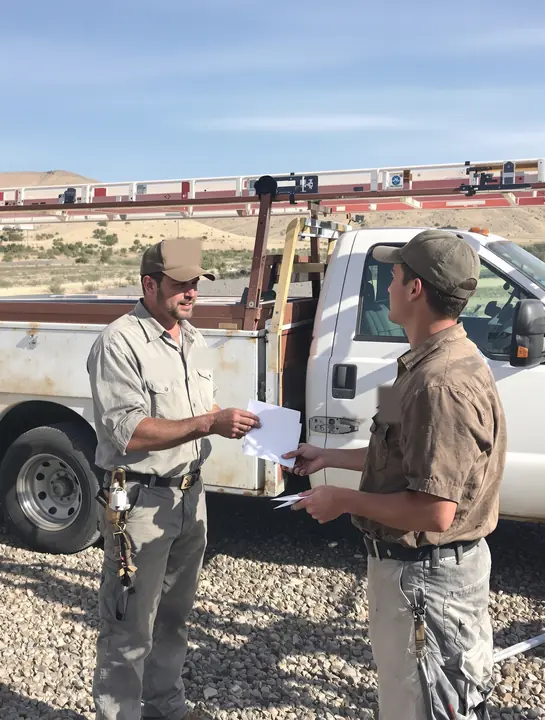 A roofing company owner hands out pay on a Friday morning
