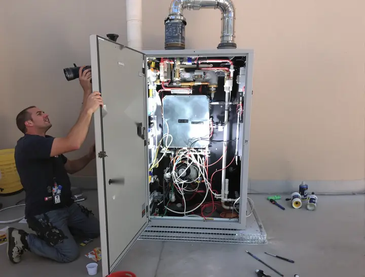 Tech checking the burner tray of a gas pool heater