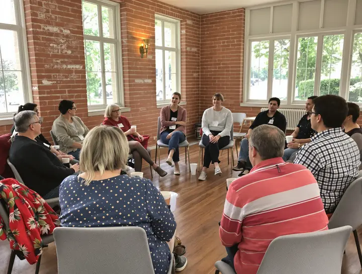 Parents and spouses in the Tuesday family group in a brick walled room