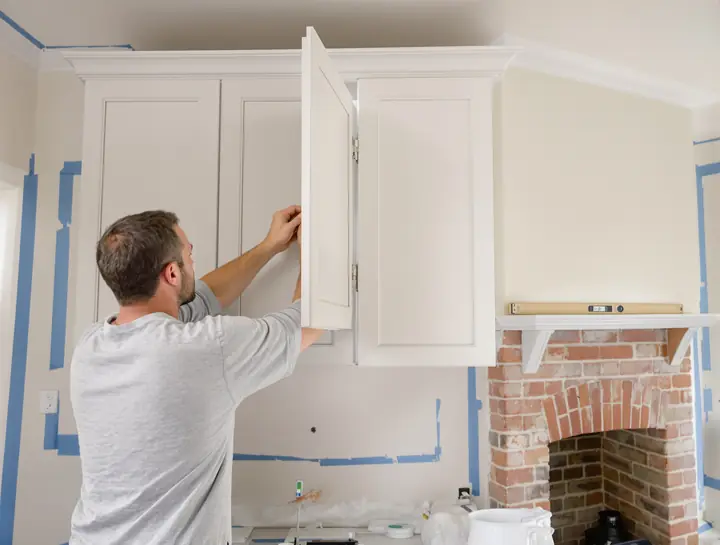 Installer adjusting a white oak cabinet door hinge