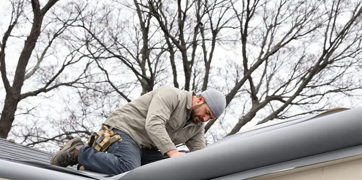 Roofer rolling out ice and water shield along the eave