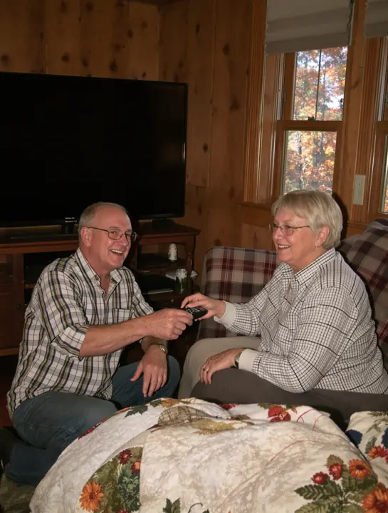 Showing an older couple how the new remote works in their living room