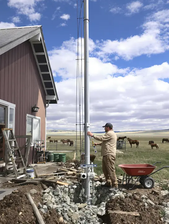 Setting a pole mount in concrete beside a ranch house