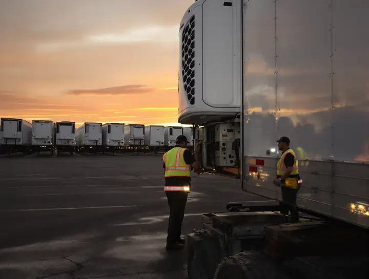 Reefer unit repair in a Laredo truck yard at dusk