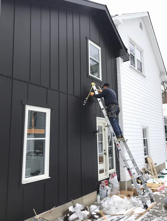 Dark steel board and batten siding on a remodeled house in Amherst