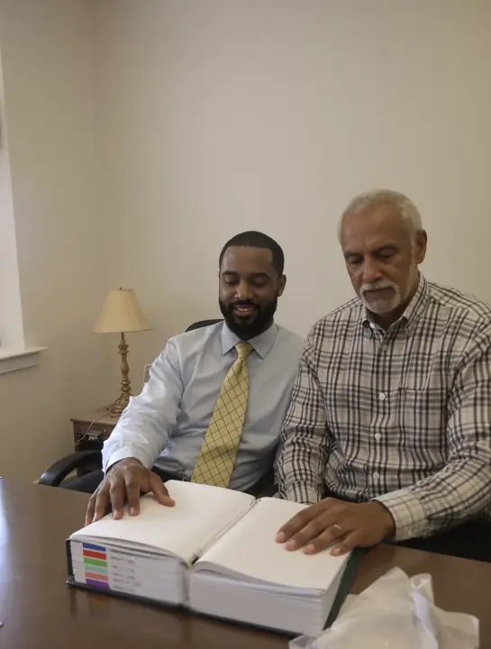 Attorney Marcus Hollins going over a client's medical records binder with him