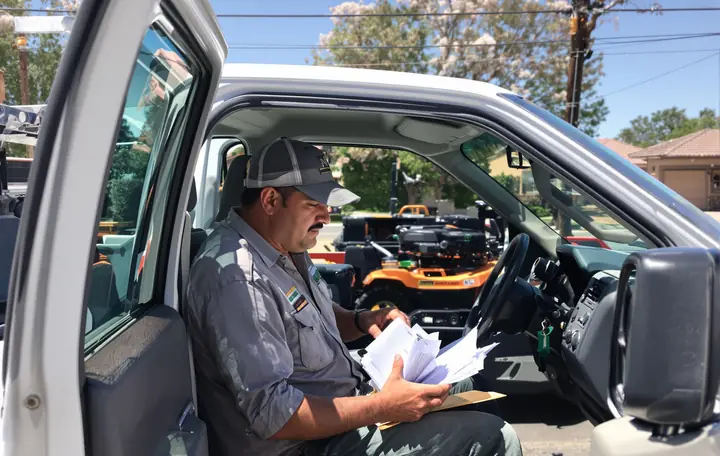 Landscaper sorting receipts in his truck cab in Surprise