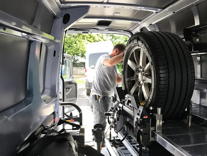 Tech mounting a tire on the tire machine inside the van