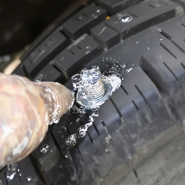 Screw in the tread with soap bubbles showing the leak
